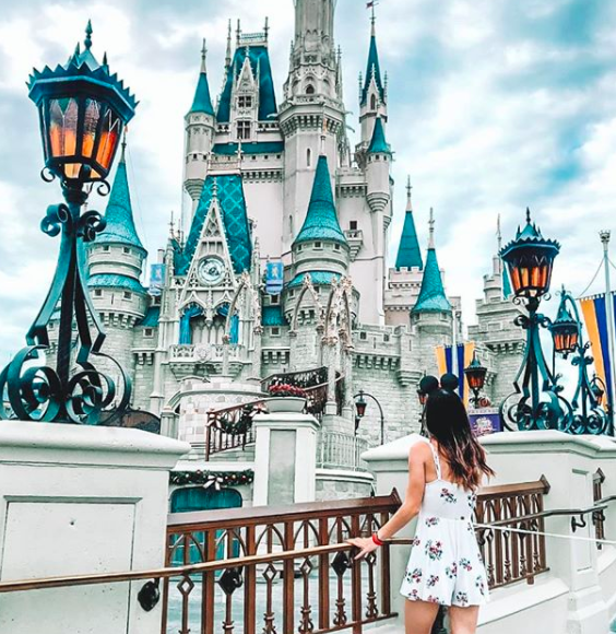 Image showing female posing in front of Cinderella's castle at Magic Kingdom. 